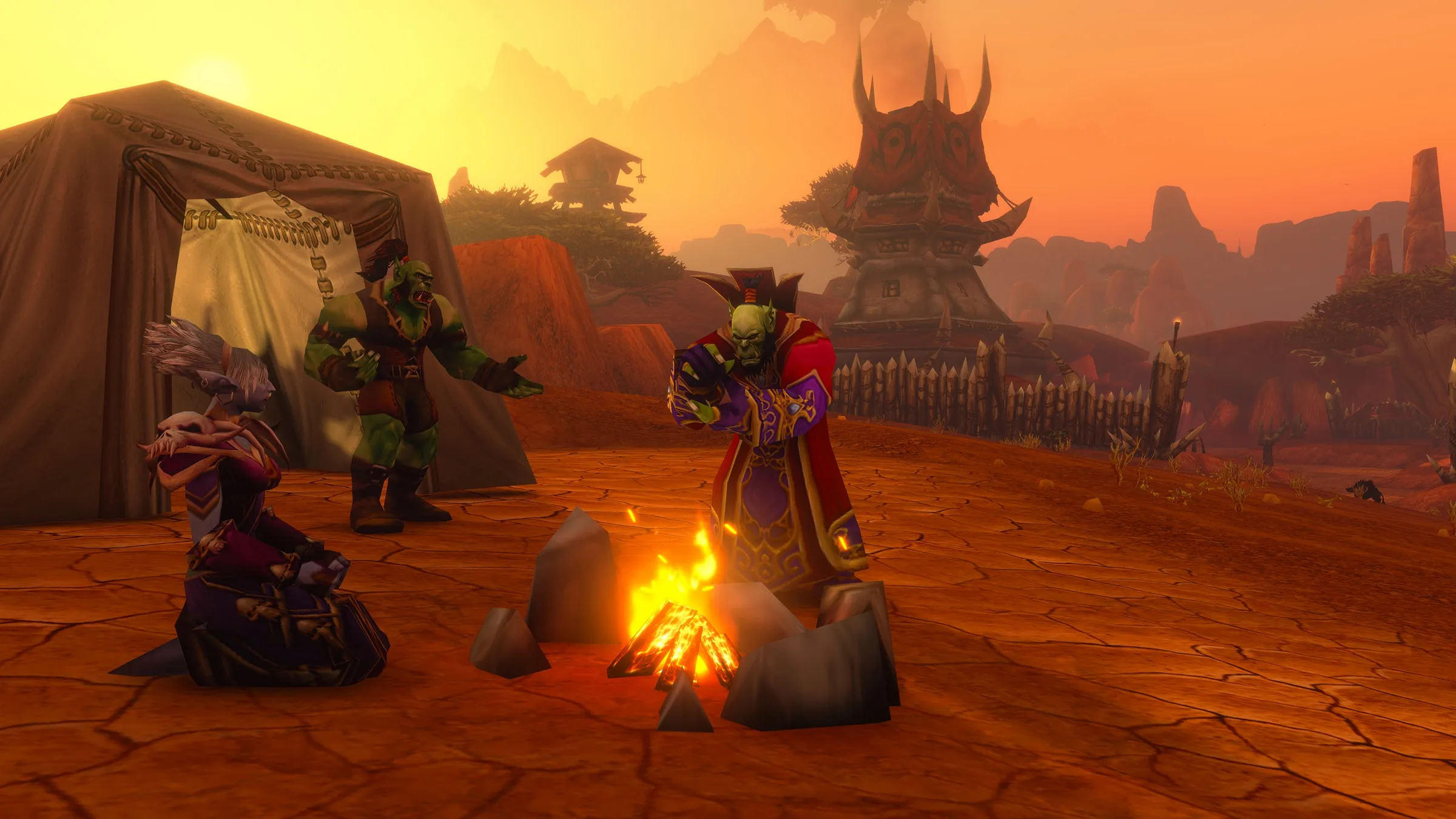 Three characters around a campfire in the Barrens at sunset, an official screenshot of World of Warcraft: Forever