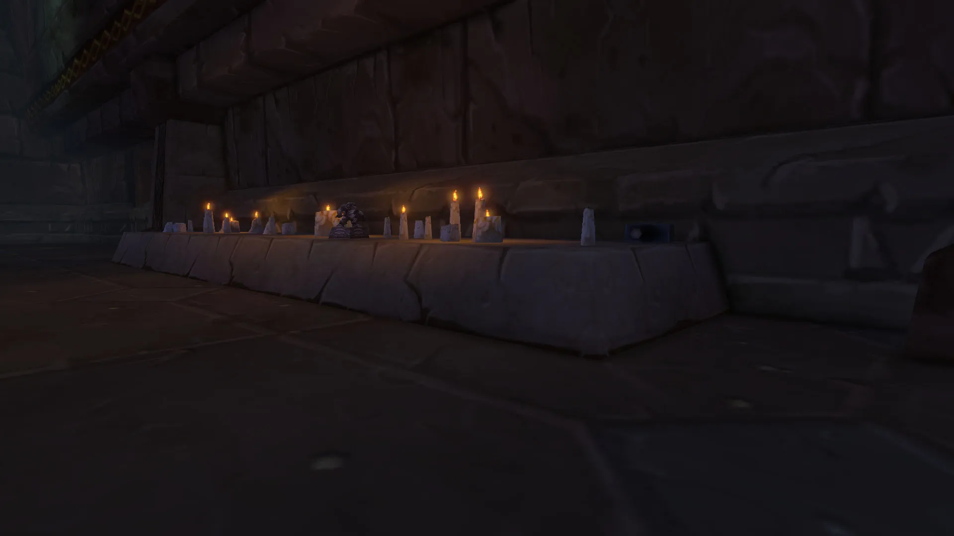 A raised stone platform with candles and Dwarven Heirlooms in a dark corridor of the Hall of Thanes