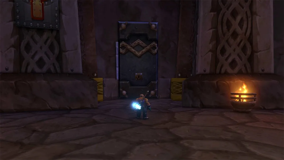 A Dwarf with a glowing weapon in front of a closed vault door in the Hall of Thanes, a screenshot from the beta of World of Warcraft: Forever