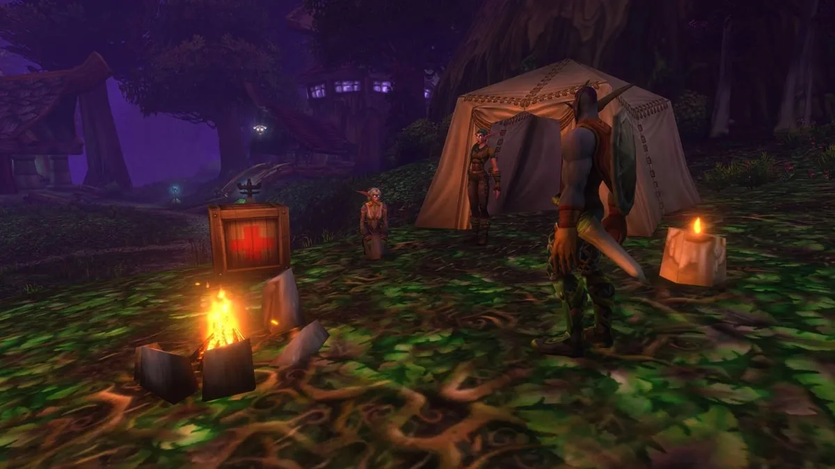 A campfire, a tent, a first aid kit and candles under the trees of Teldrassil, a screenshot from the beta of World of Warcraft: Forever