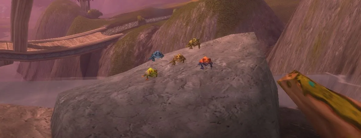 Five colourful frogs on a big rock at the top of a waterfall on Zephras Isle, a screenshot from the beta of World of Warcraft: Forever