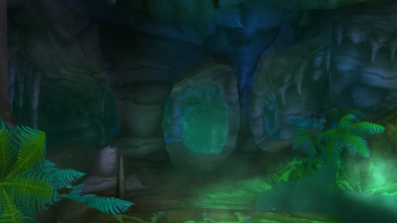 The entrance of Wailing Caverns, a cave mouth between ferns and green light, a screenshot from World of Warcraft