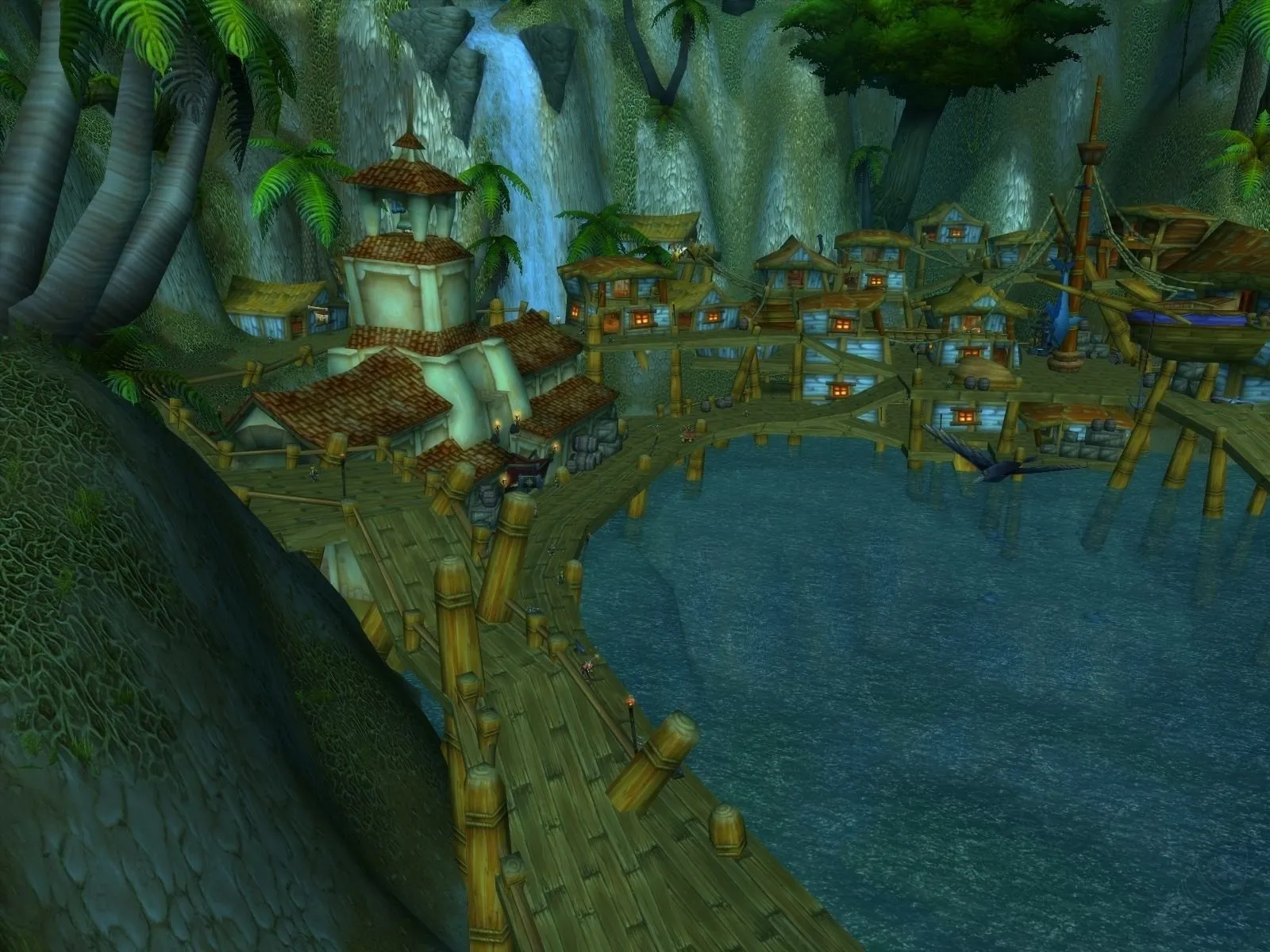 The harbour of Booty Bay with wooden piers, houses with red roofs and a waterfall against the cliffs, a screenshot from World of Warcraft