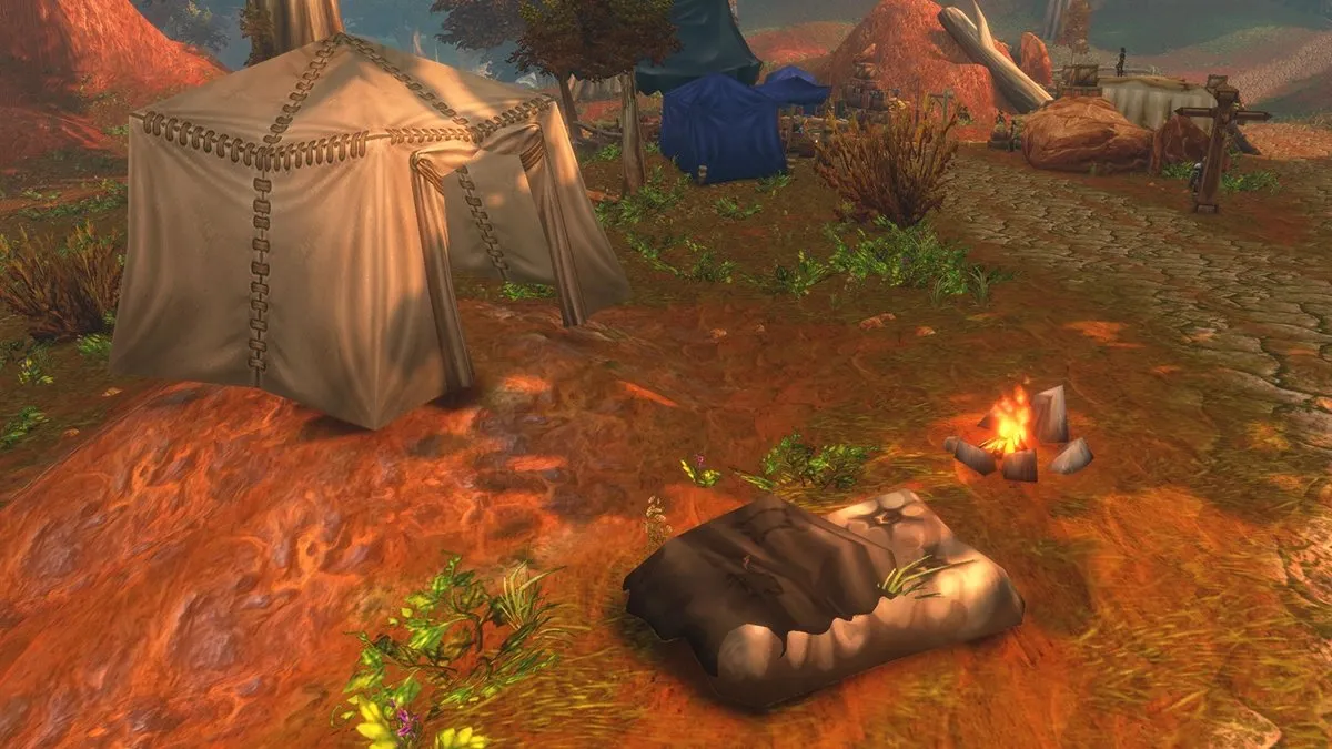 Una tenda, un fuoco da campo e un Cozy Sleeping Bag su terra rossa, uno screenshot della beta di World of Warcraft: Forever