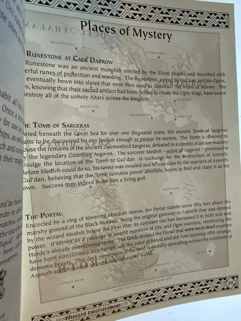 Eine Seite mit dem Titel Places of Mystery aus einem alten gedruckten Handbuch von World of Warcraft, mit dem Runestone at Caer Darrow und der Tomb of Sargeras, ein Foto von Geheimnisjägern