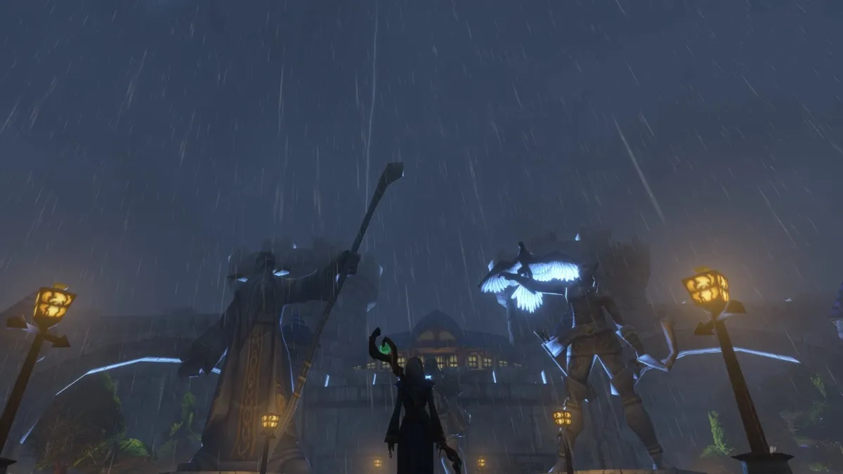 Eine Figur mit einem Stab steht nachts im starken Regen zwischen zwei großen Statuen am Tor von Stormwind, ein Screenshot aus der Beta von World of Warcraft: Forever