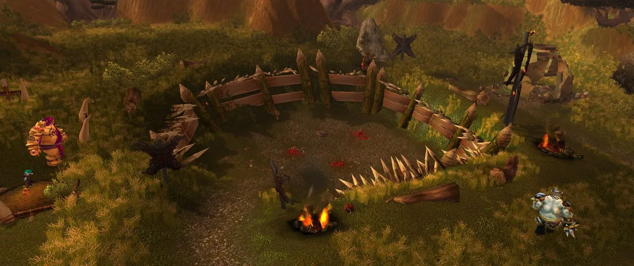 An ogre fighting pit with a fence of wooden stakes, bloodstains on the ground and a campfire, with ogres standing beside it, a screenshot from the beta of World of Warcraft: Forever