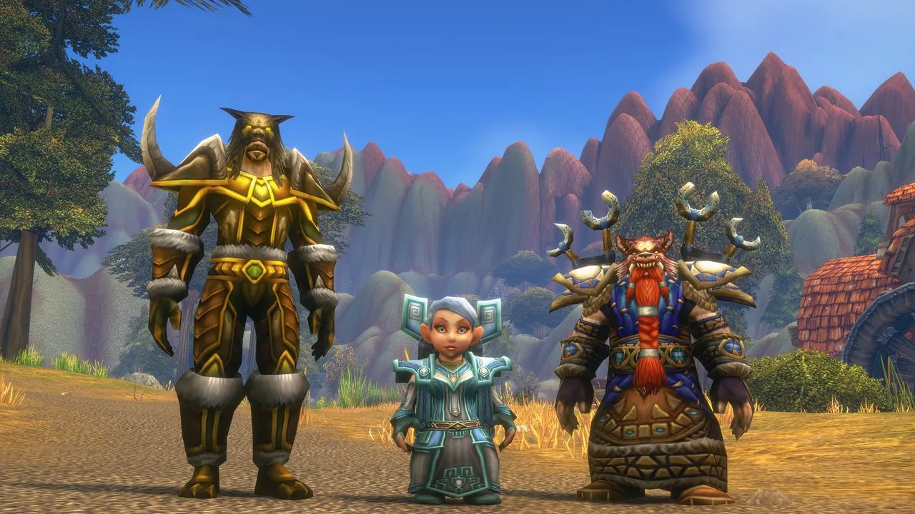 Un tauren, un gnome et un nain en armure complète côte à côte sur une herbe sèche devant des montagnes de roche rouge, une image de Blizzard de World of Warcraft: Forever