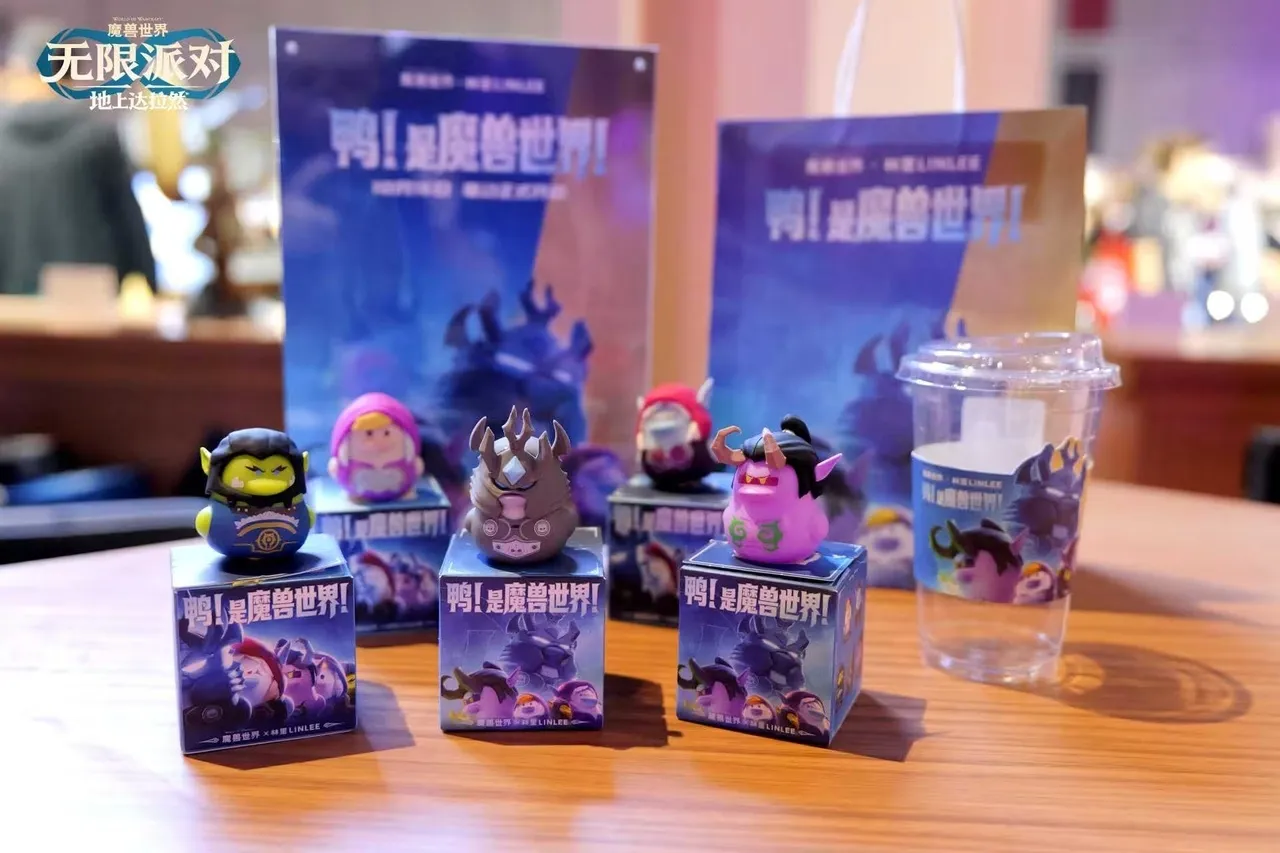 Small figures of World of Warcraft characters on boxes next to a cup with a World of Warcraft print, a photo of the Forever Party in Shanghai