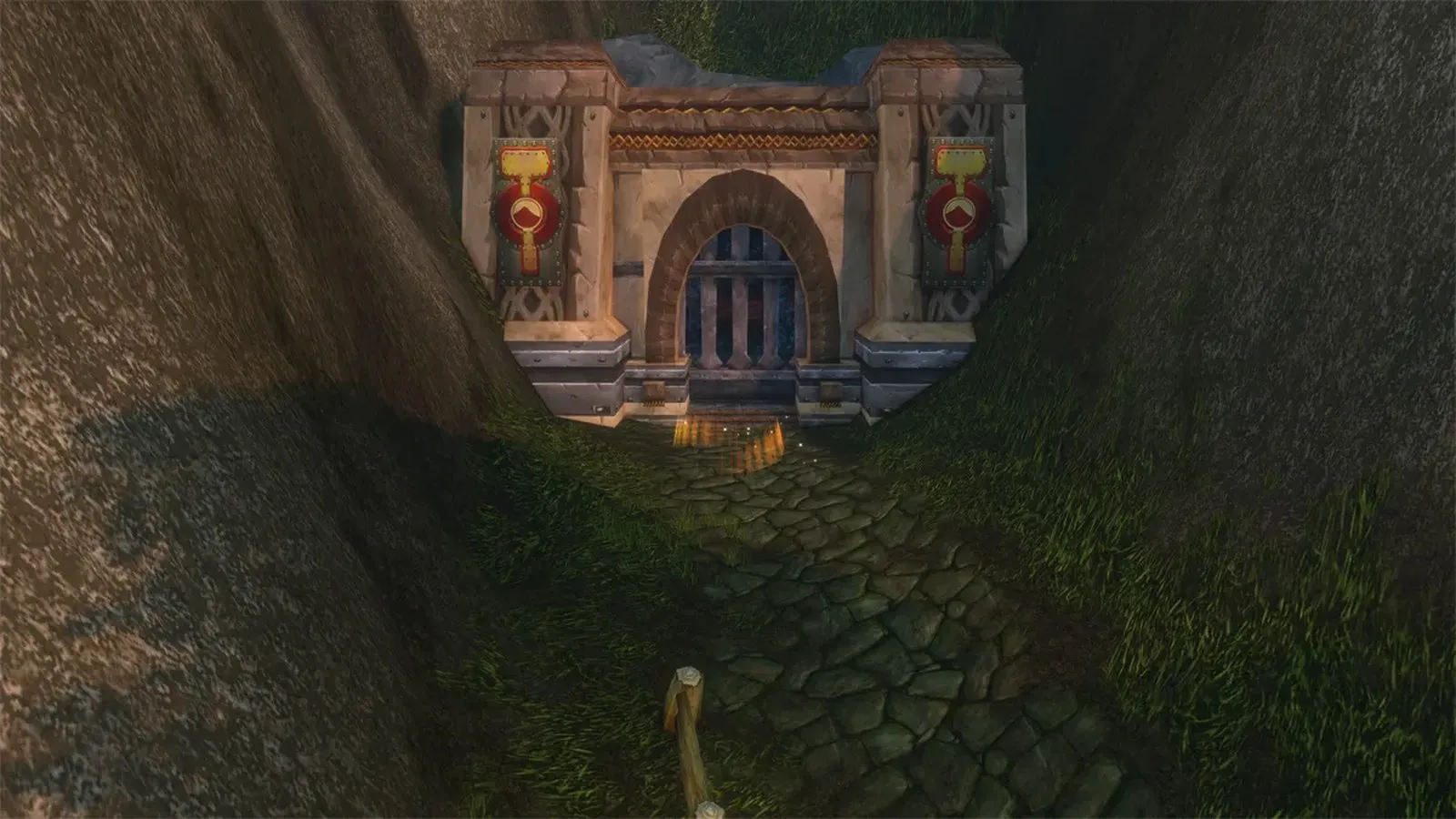 Una puerta de piedra enana con estandartes rojos al final de un camino empedrado en las montañas de los Wetlands, una captura de pantalla de la beta de World of Warcraft: Forever